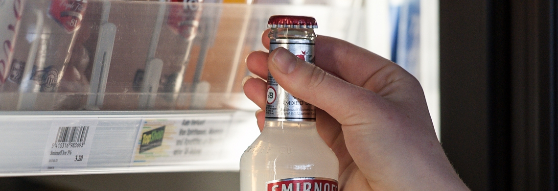 Symbolbild Alkoholverkauf: Jugendlicher nimmt alkoholisches Getränk aus dem Kühlregal